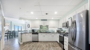 A modern kitchen with white cabinets, stainless steel appliances, and a wooden floor. - Breathtaking Views, Views, Views! Oceanfront wraparound balcony; 3 BR and 3 BA. (Orange Beach)