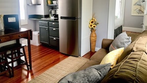 A compact kitchen with a refrigerator, microwave, and sink. - Suites on Cannon (Charleston)