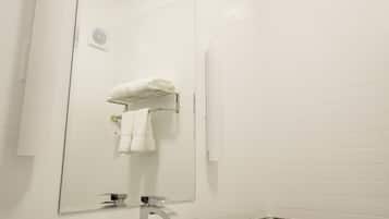 Un bagno moderno con un lavandino bianco, un piano di lavoro in granito e un grande specchio.
