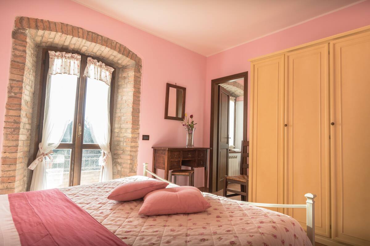 Une chambre à coucher avec un lit, une commode, un miroir et une armoire.