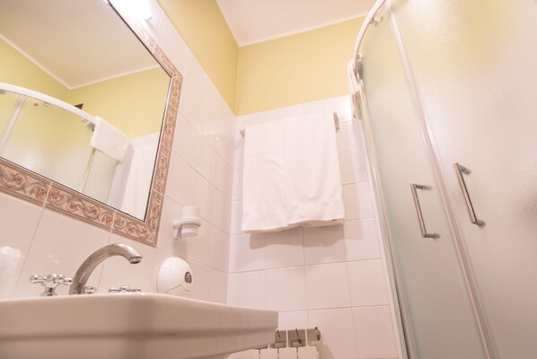 Un baño con lavamanos, espejo y ducha.