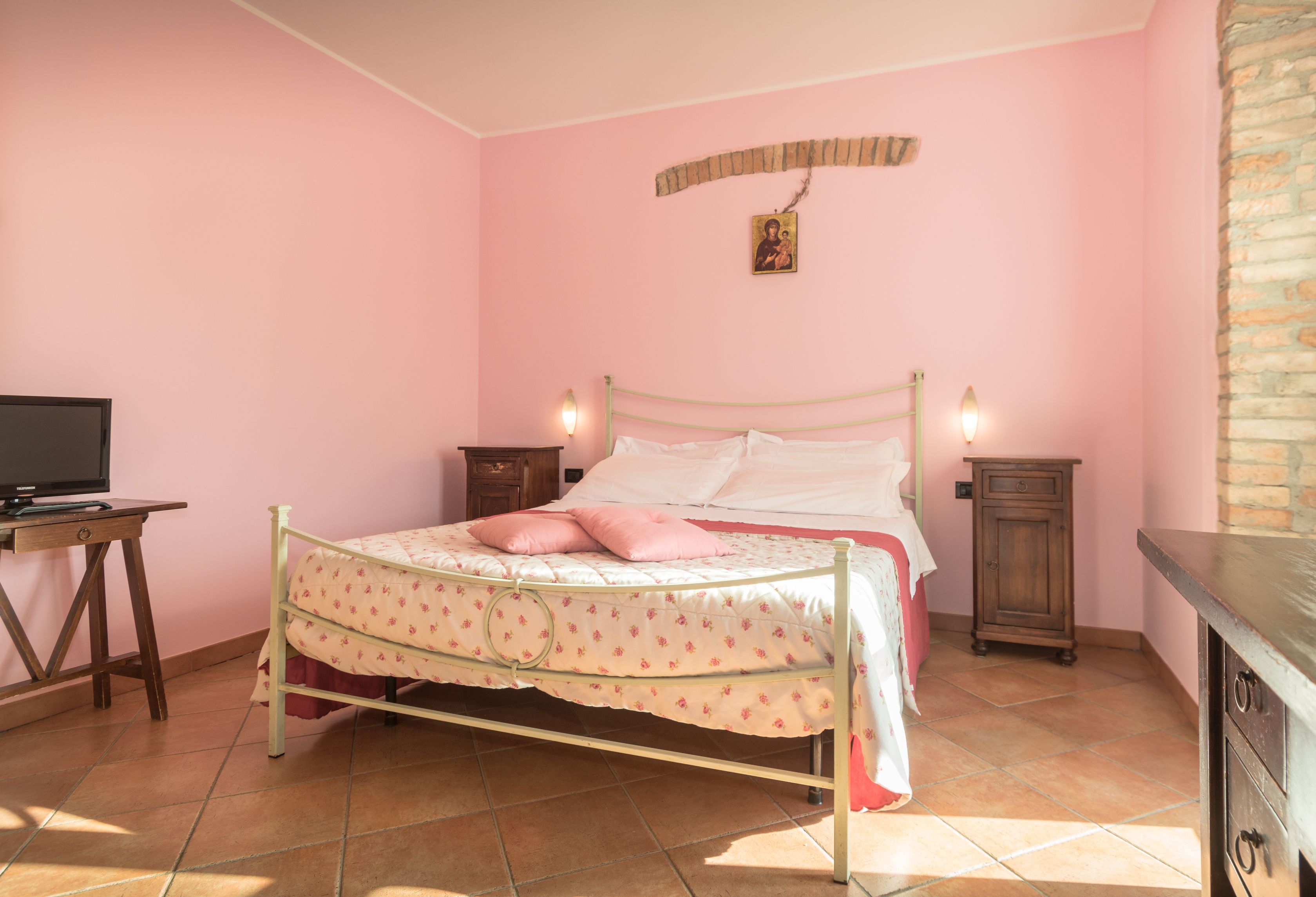Une chambre à coucher comprenant un lit, des tables de chevet, une commode et un téléviseur.