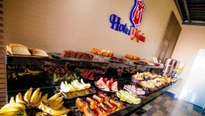 Un bufé con diferentes alimentos, incluyendo plátanos, frutas y pasteles.