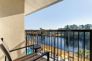 A balcony with a view of a river, outdoor seating, and a pool. - Four Points by Sheraton Myrtle Beach (Myrtle Beach)