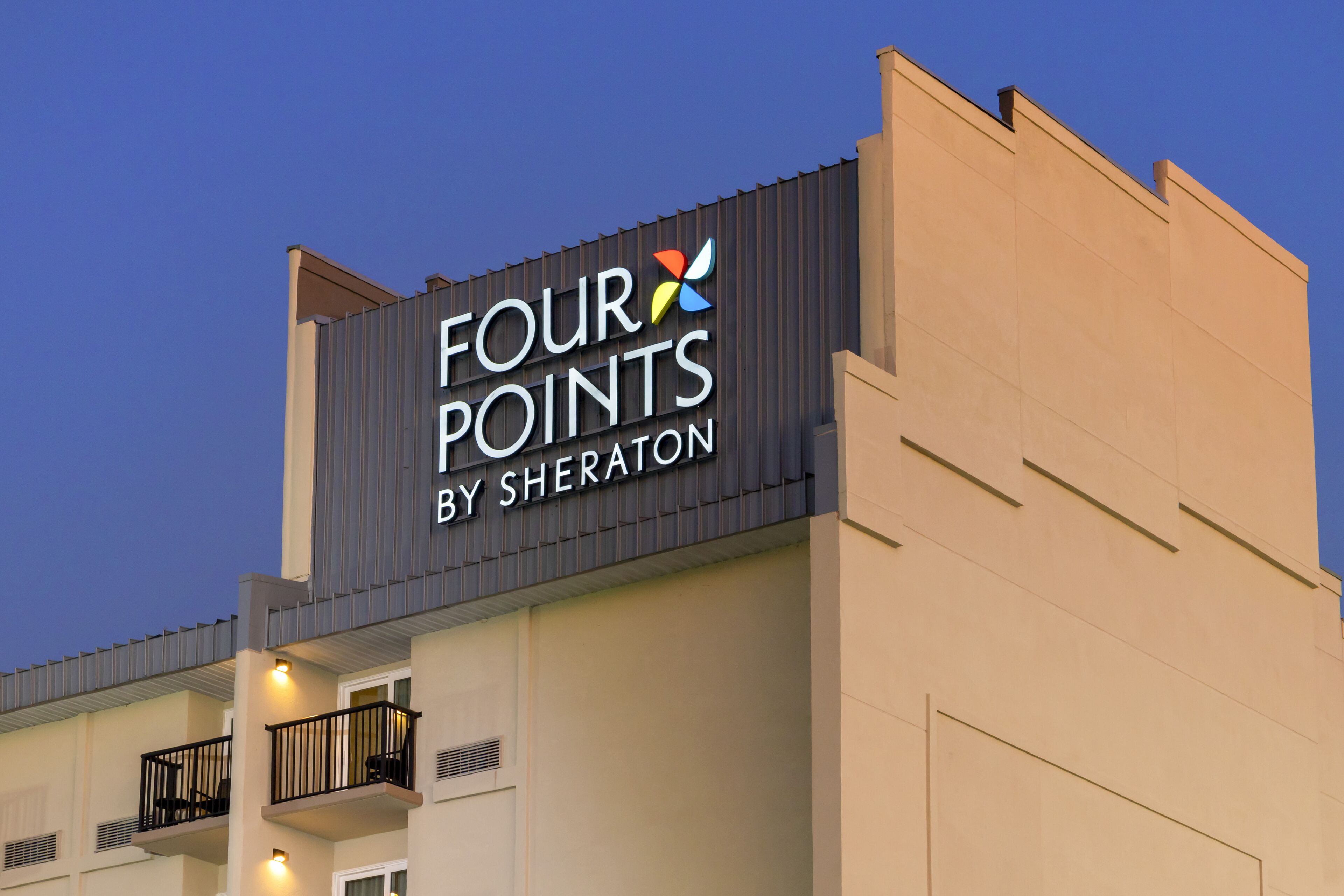 A hotel sign with the name "FOUR POINTS BY SHERATON" and a colorful logo.