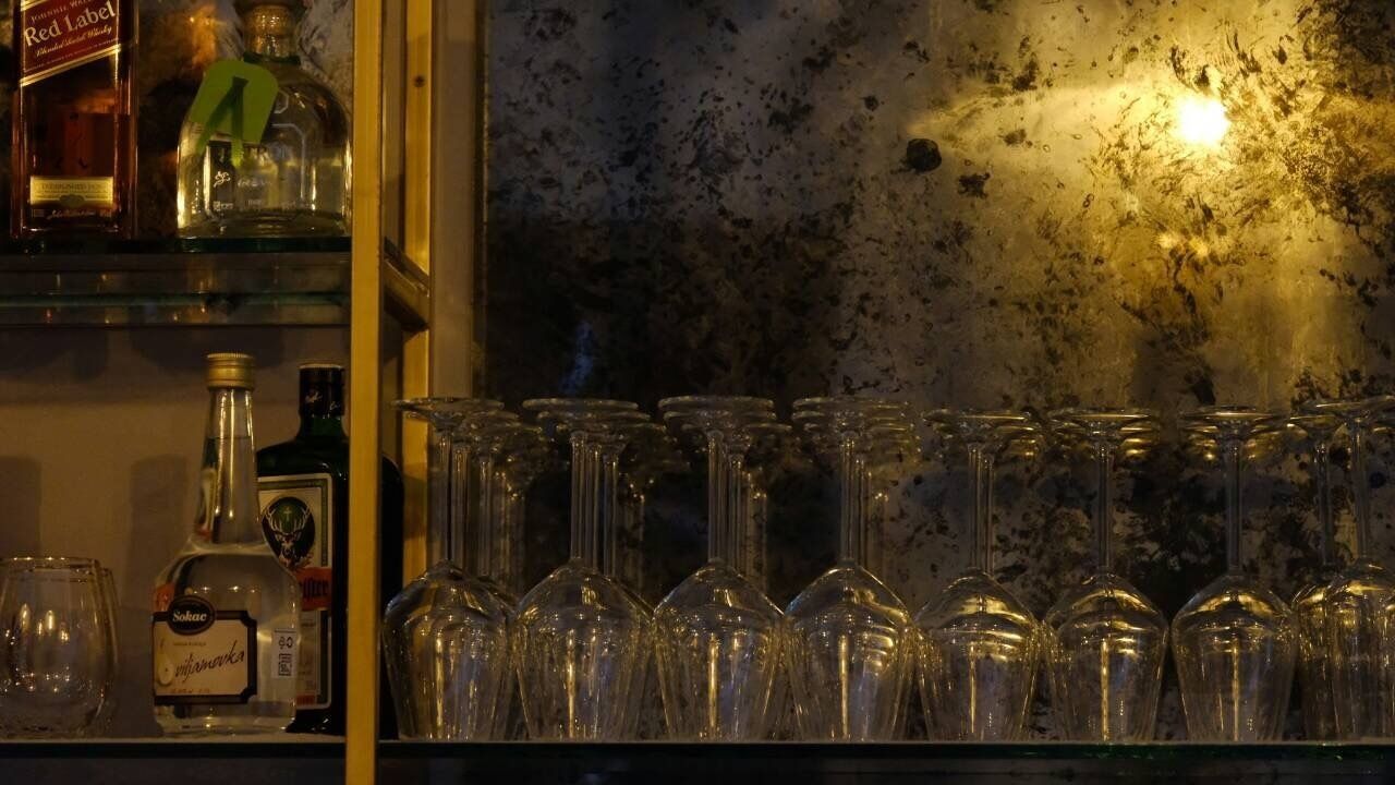 Una zona de bar con botellas y vasos.