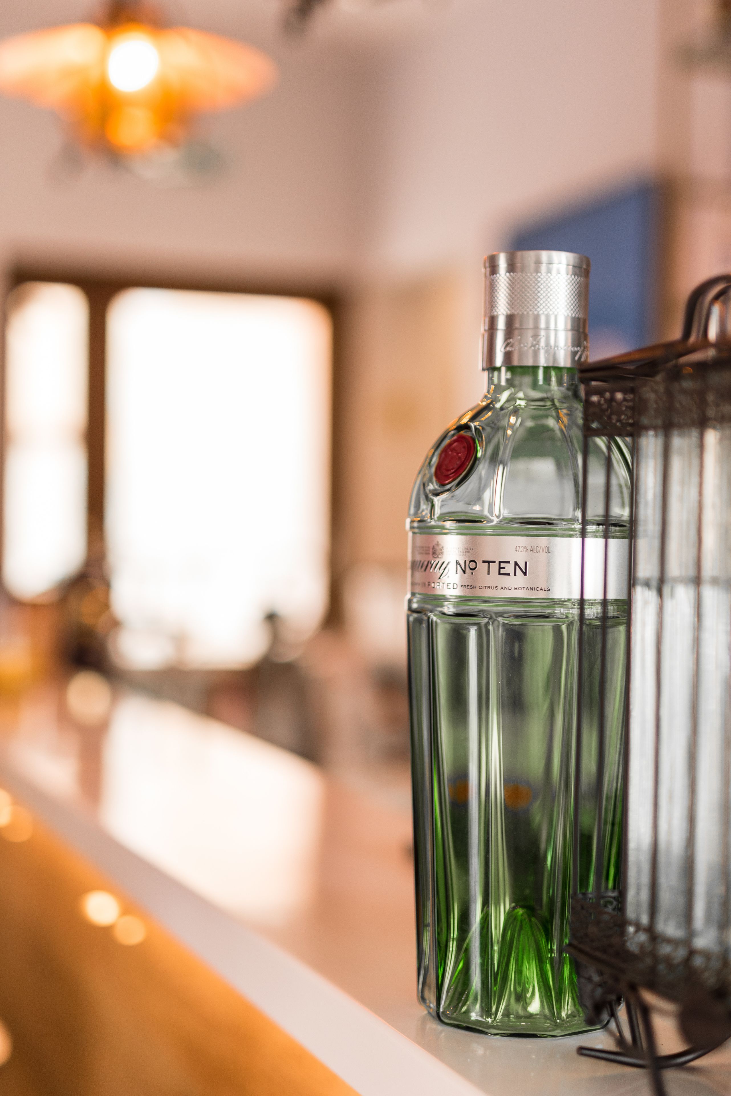 A bar area with a glass bottle labeled "N° TEN" and a metal container.