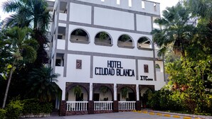 A multi-story building with the sign "HOTEL CIUDAD BLANCA" indicating it is a hotel. - Hotel Ciudad Blanca (Copan Ruinas)
