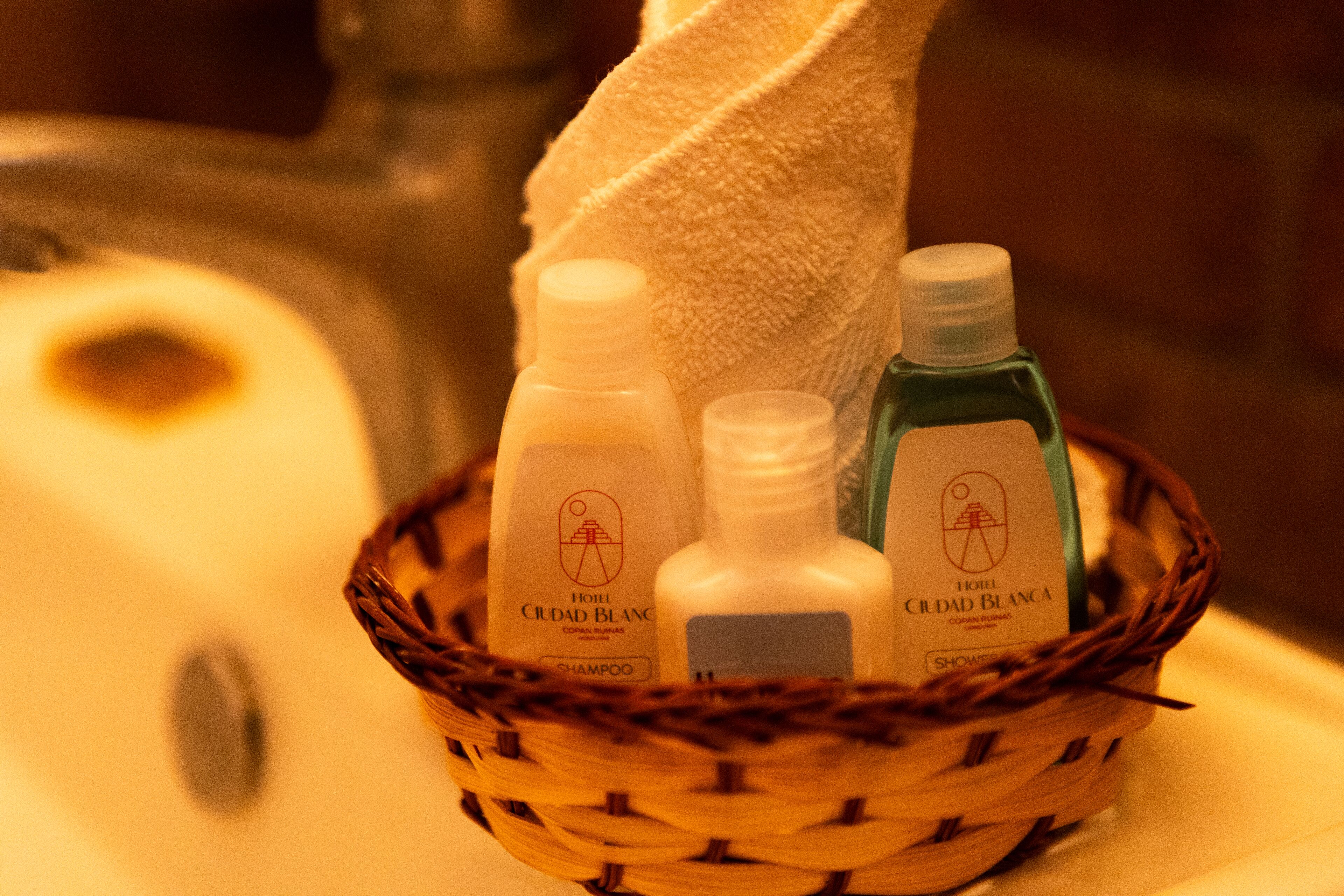 Una cistella amb productes de tocador, com xampú i gel de dutxa, damunt d'una superfície del bany.