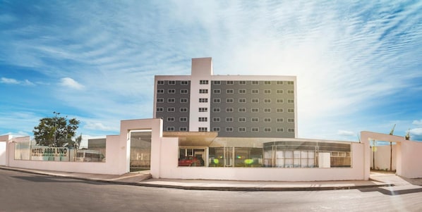 Um hotel moderno com um edifício central e entrada de vidro.