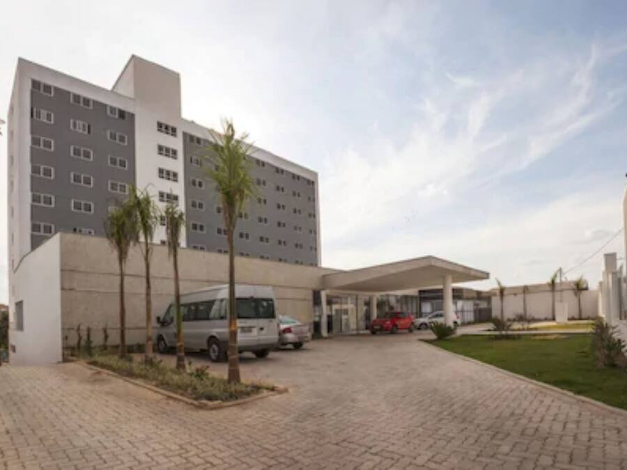 A modern building with multiple floors, a covered parking area, and a paved driveway.