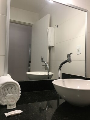 A bathroom with a white sink, two faucets, a towel, and a mirror. - Hotel Abba Goiana (Goiana)