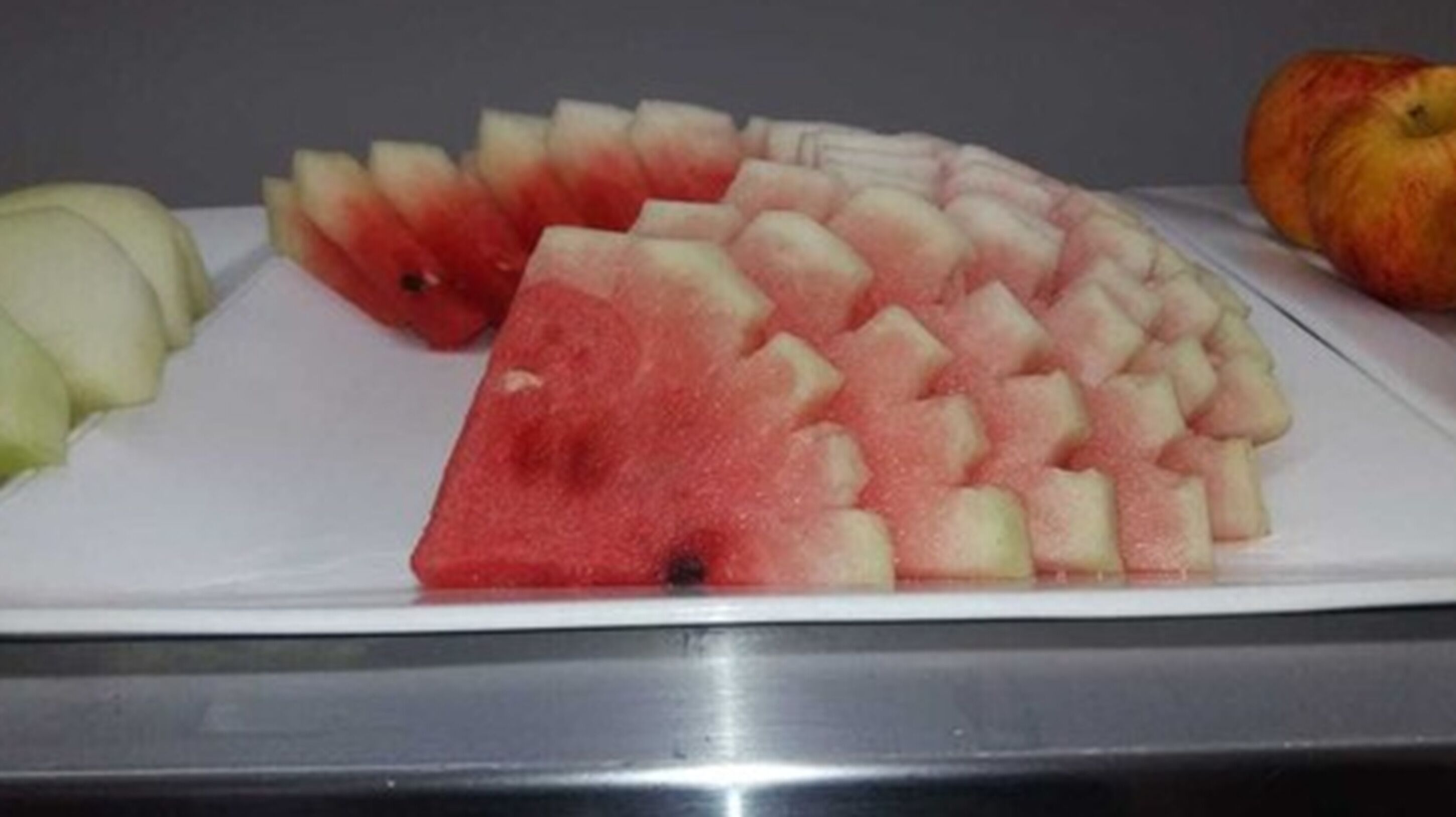 Um prato com melancia em cubos e fatias de melão.