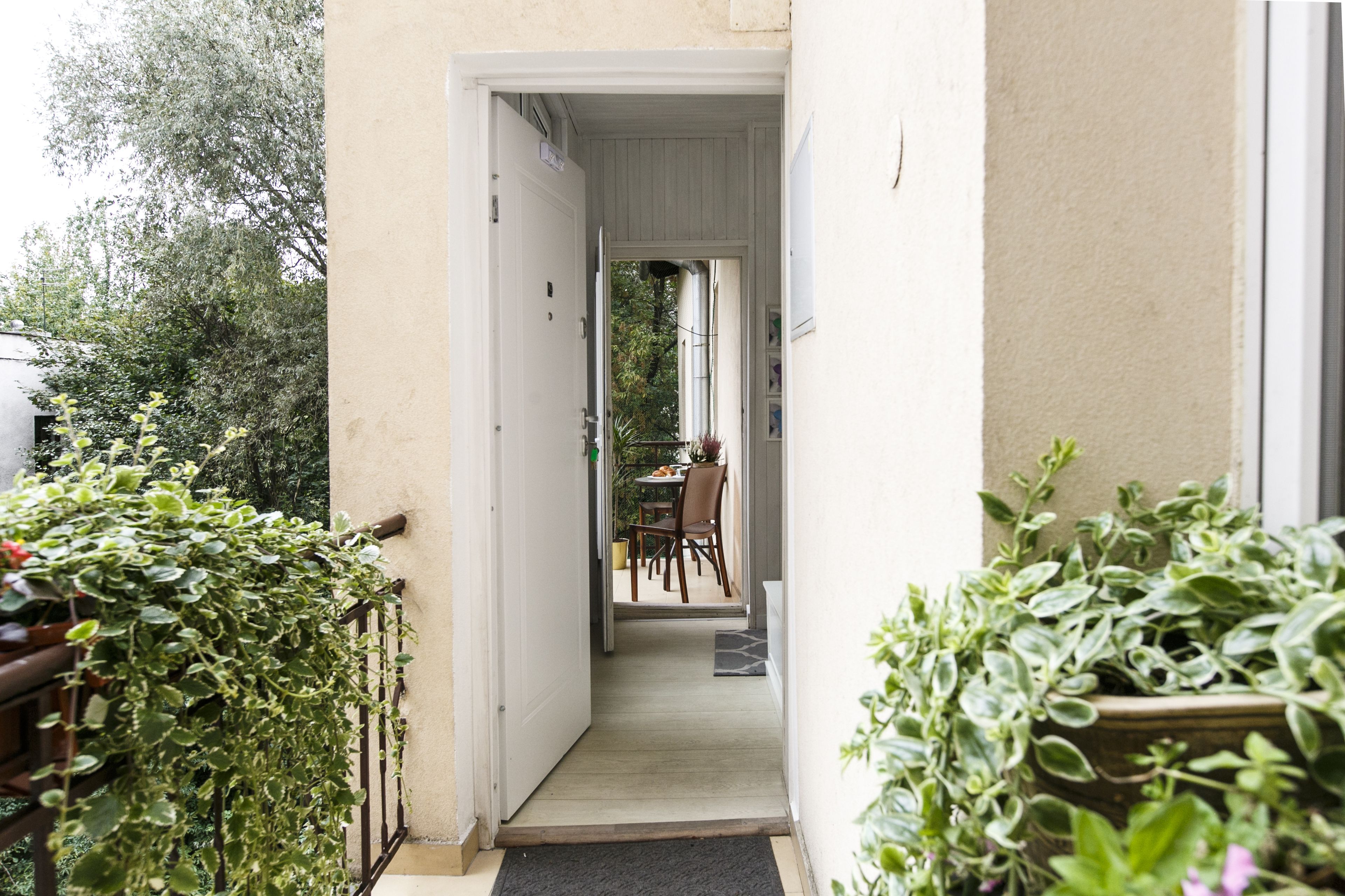 A narrow pathway leading to a dining area with a table and chairs.