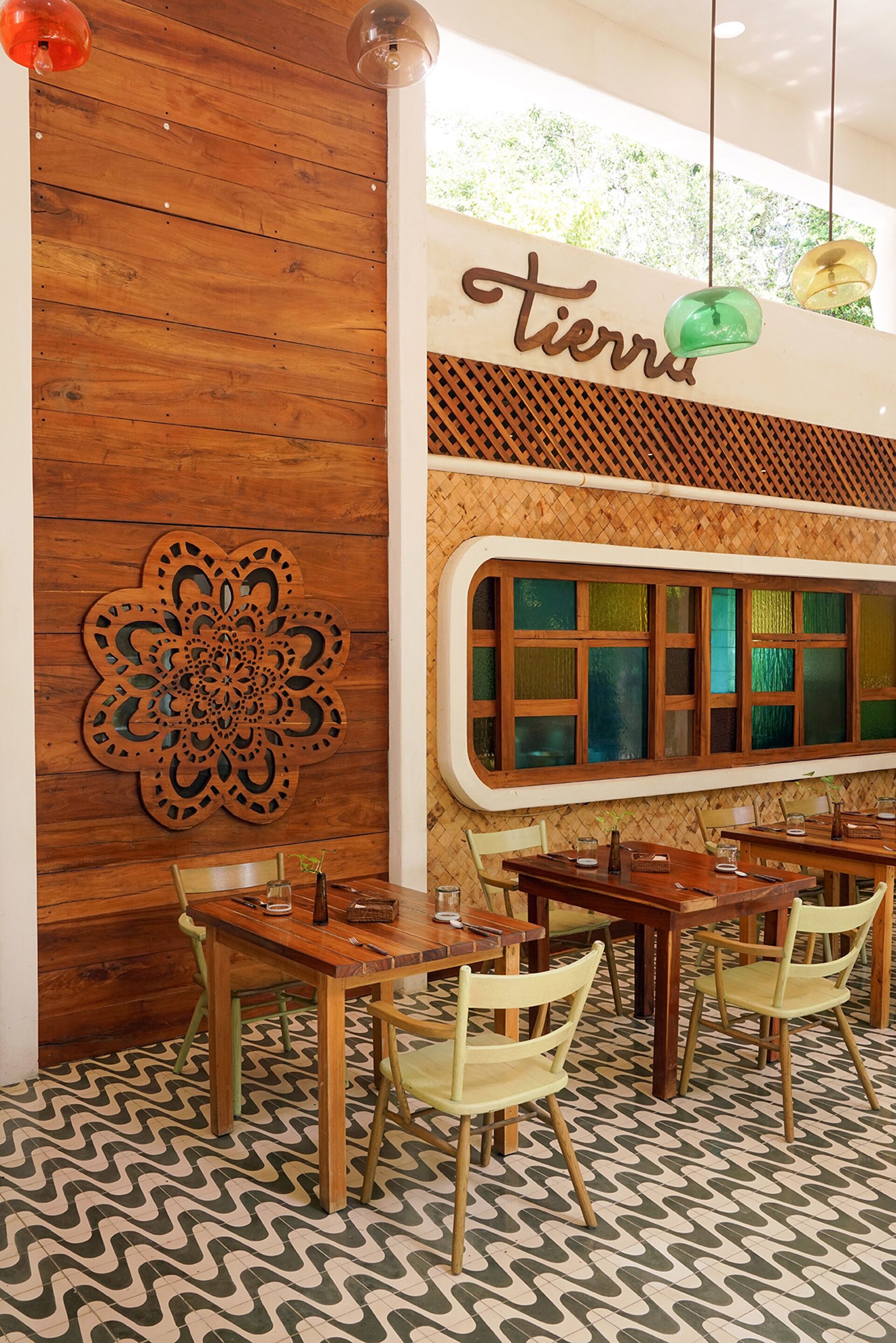 Interior de restaurante con paredes de madera, un gran recorte decorativo y suelo estampado.
