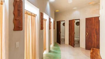 A hallway with wooden doors and a green carpet.