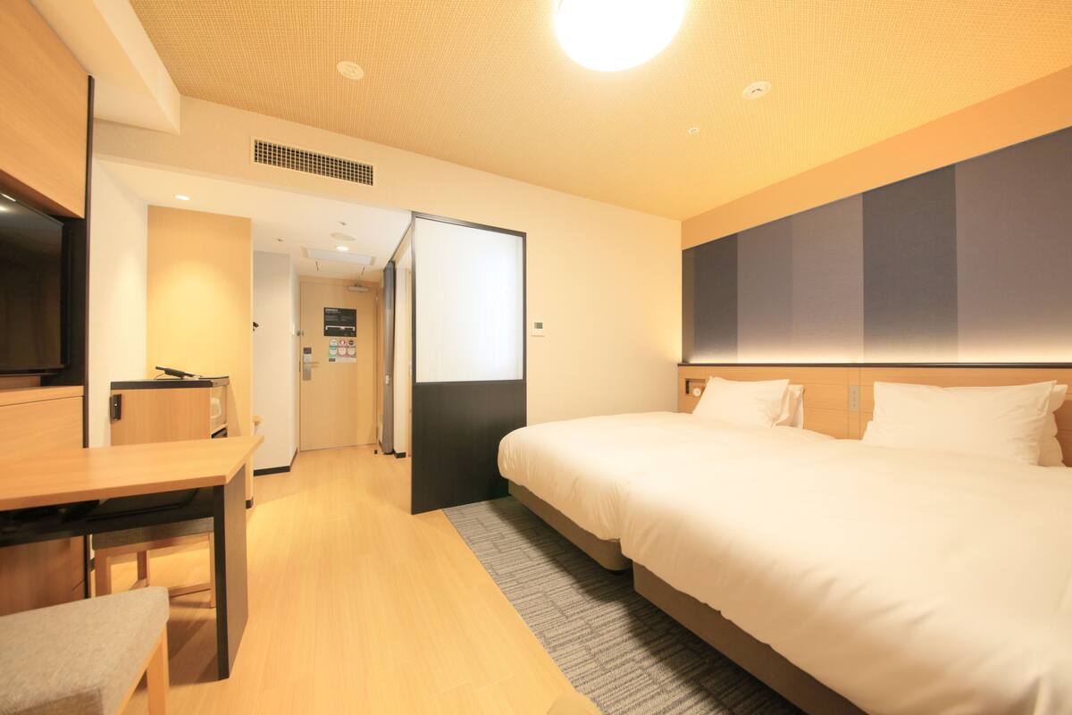 Ein Hotelzimmer mit einem Bett, einem Schreibtisch und einem Fernseher.