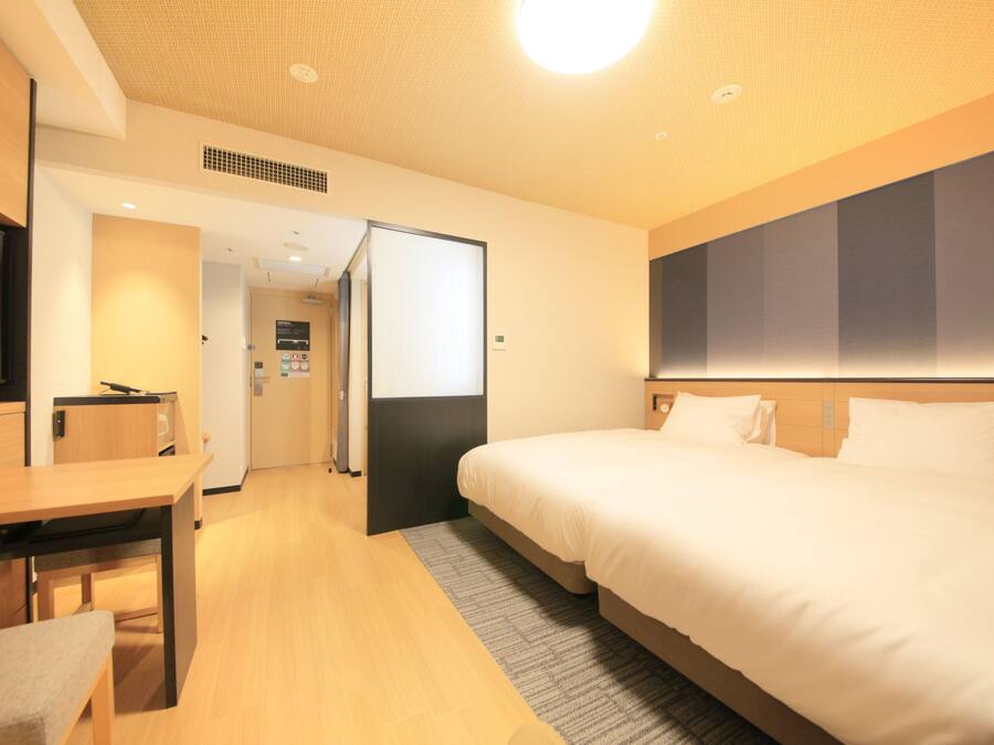 Ein Hotelzimmer mit einem Bett, einem Schreibtisch und einem Fernseher.
