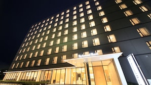 Un hôtel de grande hauteur, doté d’une façade moderne, de nombreuses fenêtres et d’une entrée imposante.