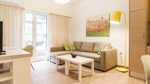 A living room with a sofa, a coffee table, a lamp, and a painting on the wall. - Superb under the Acropolis, walking distance to all attractions,  (Athina)