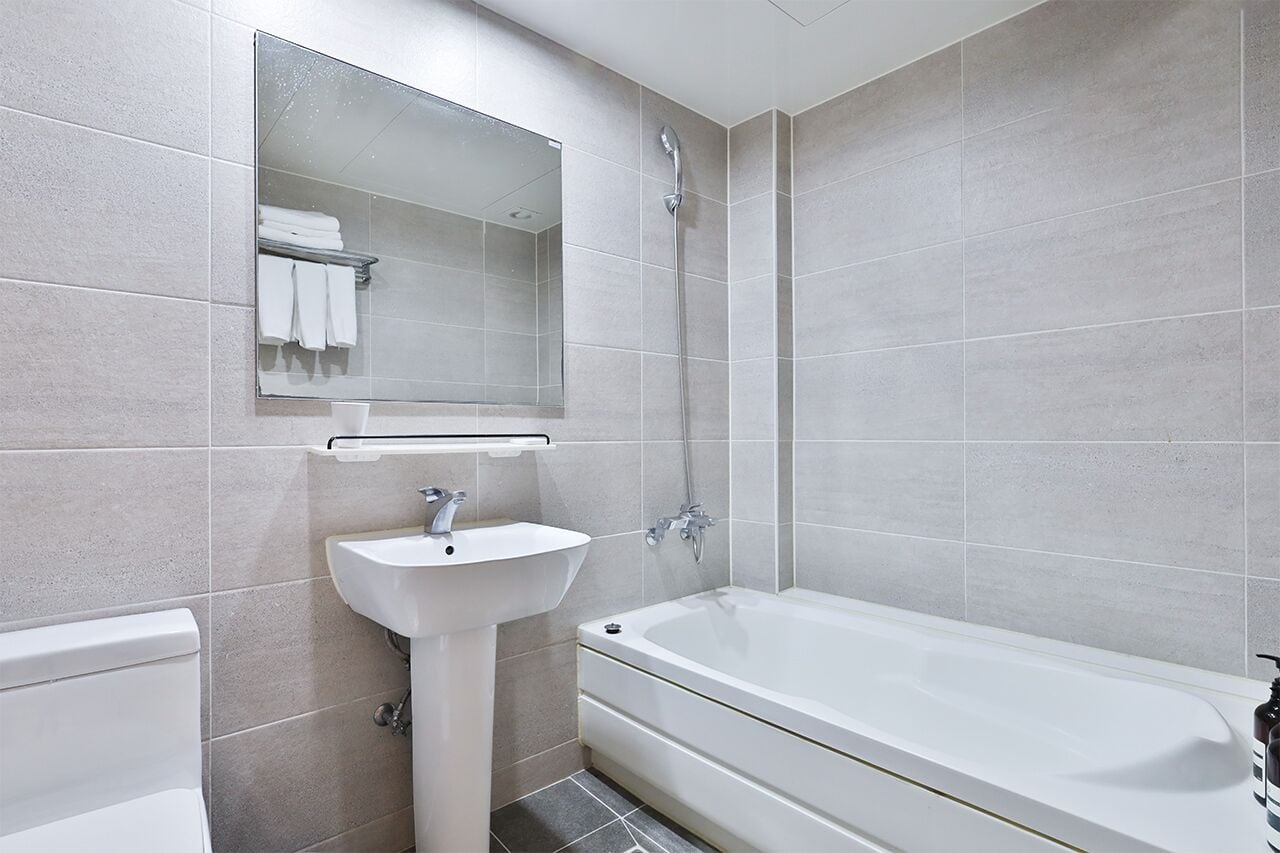A modern bathroom with a bathtub, a sink, and a mirror.