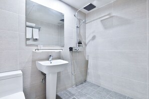 A modern bathroom with a white sink, a mirror, and a shower.