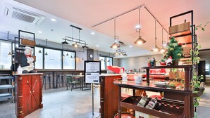 Un interior de restaurante con mostrador de madera, luces colgantes y un árbol de Navidad.