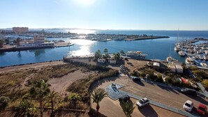 A marina with boats, a parking area, and a hilly landscape. - 6th floor apartment ideal for families, free wifi, balcony, sea views (La Manga del Mar Menor)