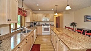 A kitchen with granite countertops, wooden cabinets, a stove, and a microwave. - Little Sandy Pond - Plymouth Estate • Family & Exec Stays • Sleeps 16 (Plymouth)