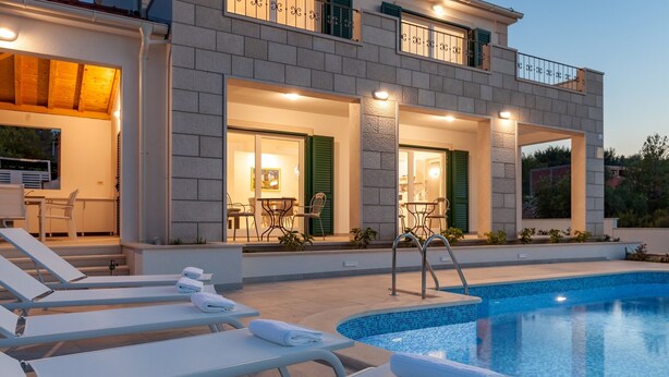 Ein modernes Hotel mit Schwimmbad, Außenbereich und gut beleuchtetem Eingang.