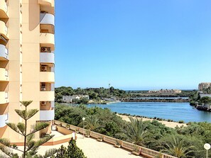 A high-rise building with balconies overlooking a river and a beach. - Family 5th floor apartment, sea views, balcony, communal pool, padel (La Manga del Mar Menor)