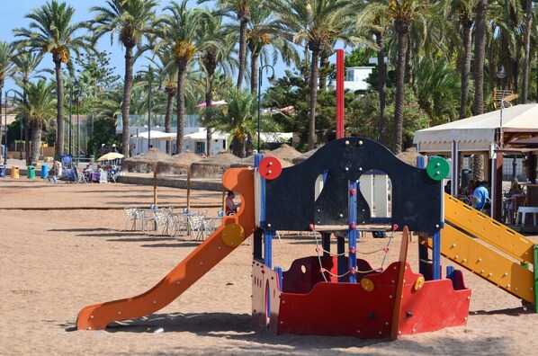 Une aire de jeux de plage avec un toboggan et une structure d’escalade.