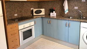 A kitchen with blue cabinets, a microwave, a coffee maker, and a sink. - Front line sea view penthouse apartment, roof terrace, communal pool (Los Nietos)