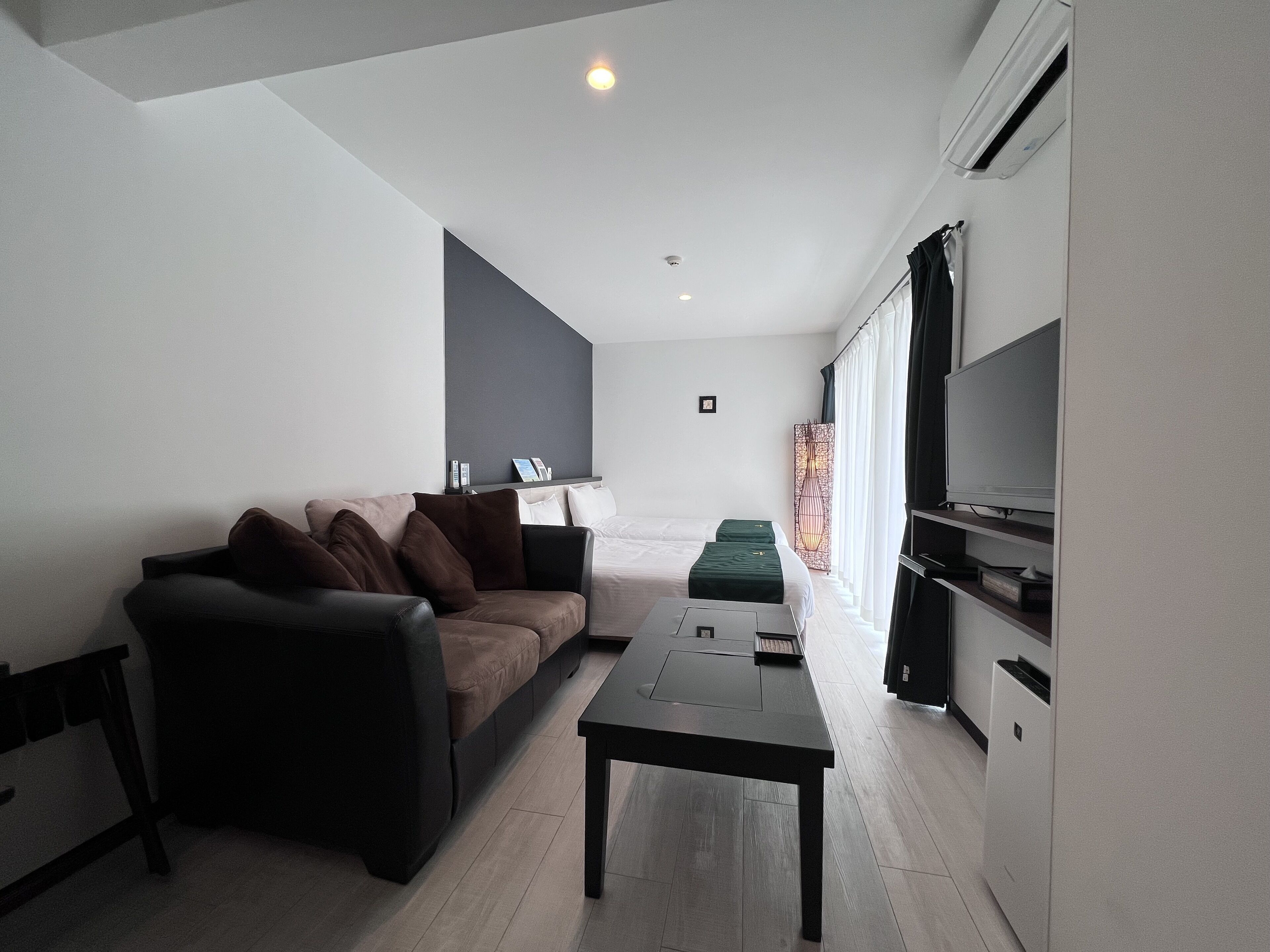 En moderne stue med sofa, sofabord og et fladskærms-tv.