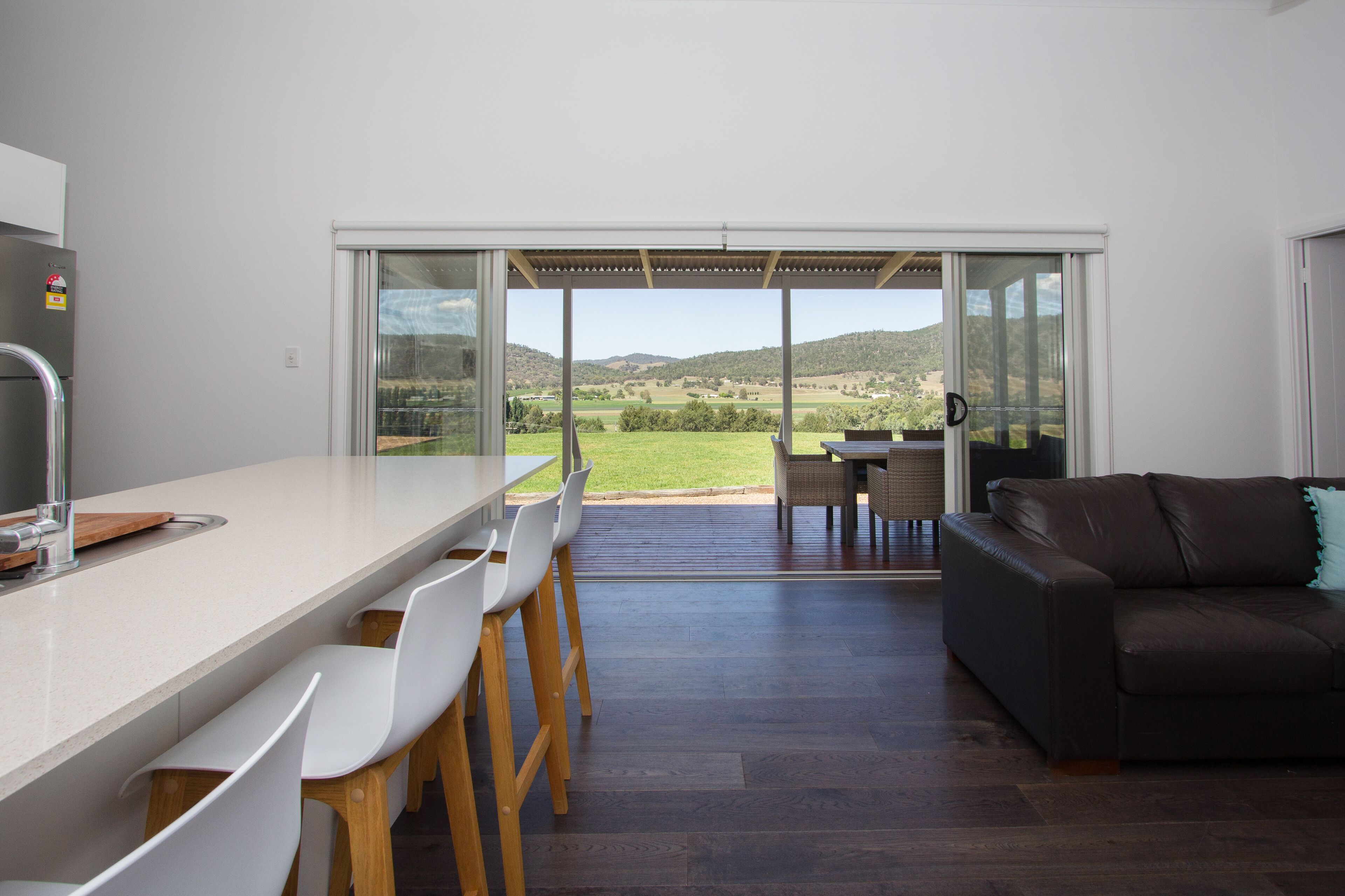 Una cucina moderna con un'area bar, un'area pranzo con sedie e un divano.