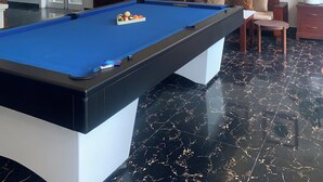 A pool table with balls, a billiard cue, and a pool table cloth. - fullhouse hoian (Da Nang)