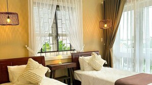 A hotel room with two beds, a desk, and a window with sheer curtains. - fullhouse hoian (Da Nang)