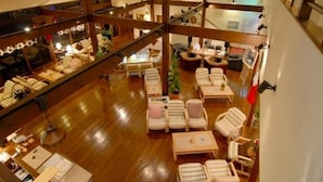 A spacious hotel lobby with multiple seating areas, a reception desk, and a staircase leading to an upper level. - Gallery Court OFA ATU (Kawazu)