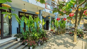 A courtyard with potted plants, hanging lanterns, and a staircase leading to a building entrance. - Smart Garden Homestay (Da Nang)