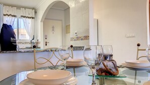 A dining area with a glass table set for four, including plates, bowls, wine glasses, and cutlery. - Penthouse, private roof terrace, balcony, Free WiFi Internet, pool (Mar de Cristal)
