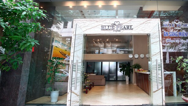 The entrance to the Blue Pearl Hotel with a marble facade, a reception desk, and a view of the interior. - Blue Pearl Hotel (Hanoi)