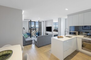 A modern apartment with a kitchen, dining area, and living space. - Imagine Lighthouse (Melbourne)