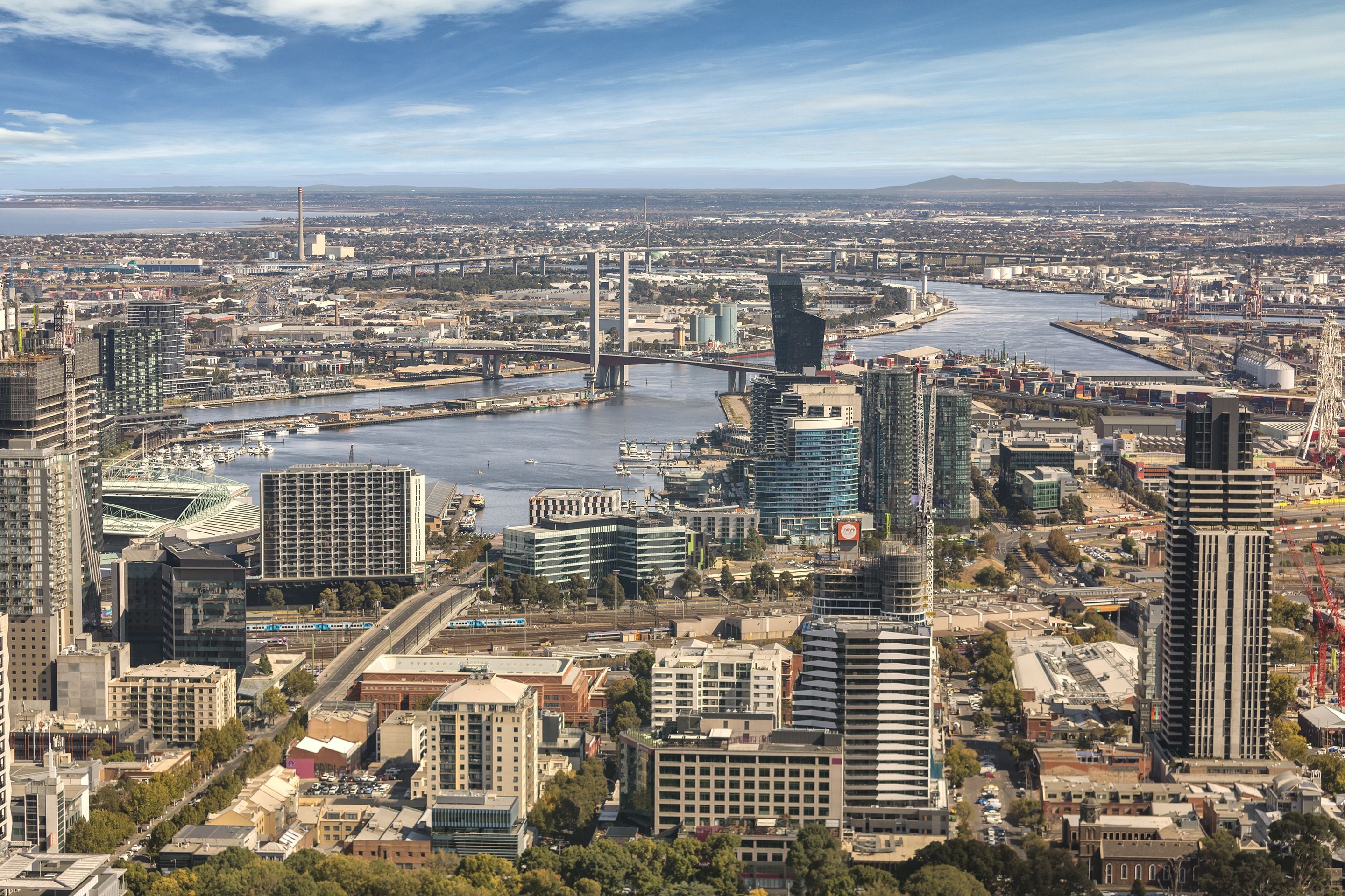 A cityscape with modern buildings, a river, and a bridge.