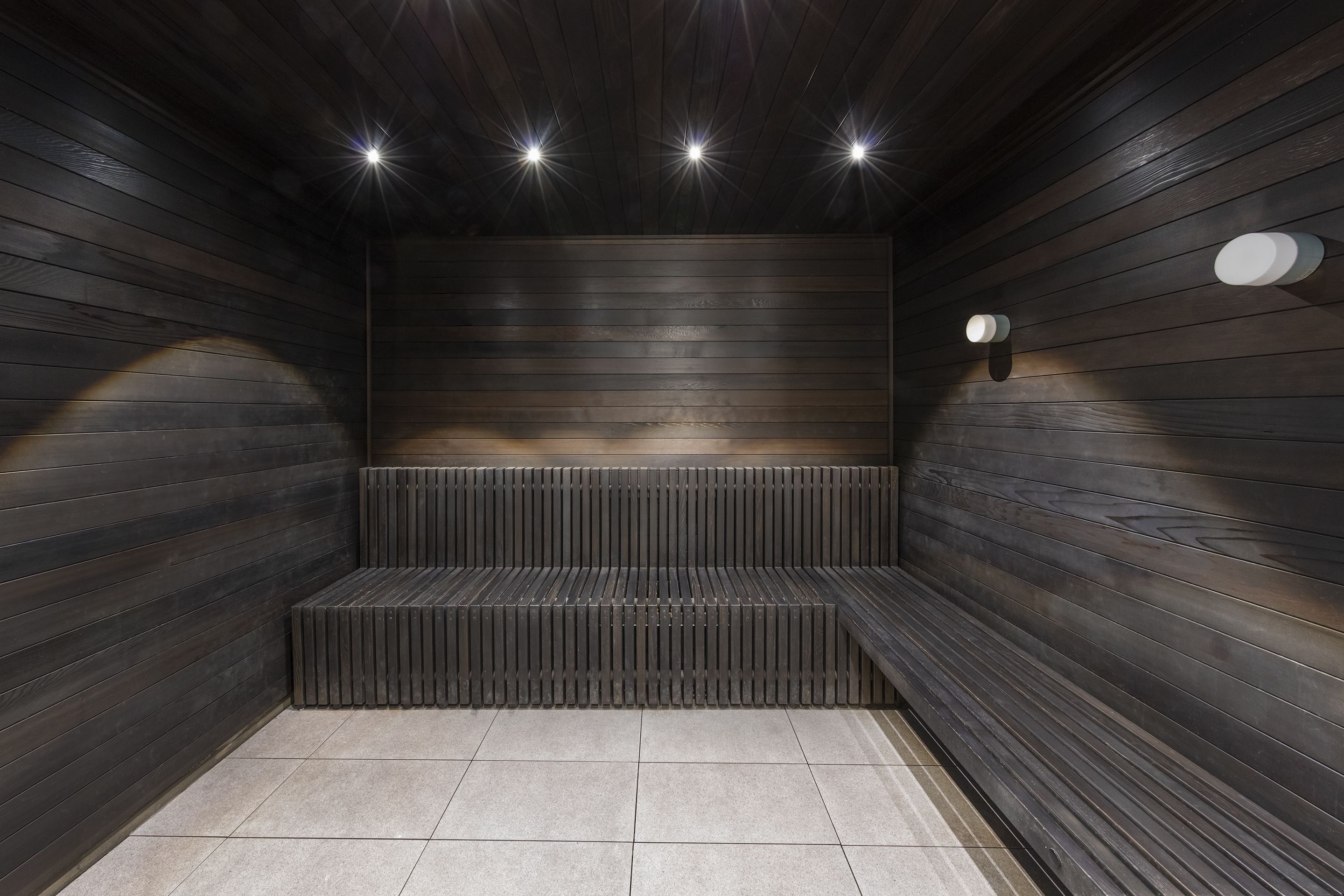 En moderne sauna med trævægge og en bænk.