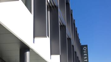 A building with a sign that reads "QUEST" on the side.