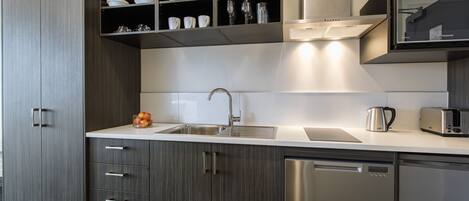Una cocina moderna con lavavajillas, fregadero y horno empotrado.