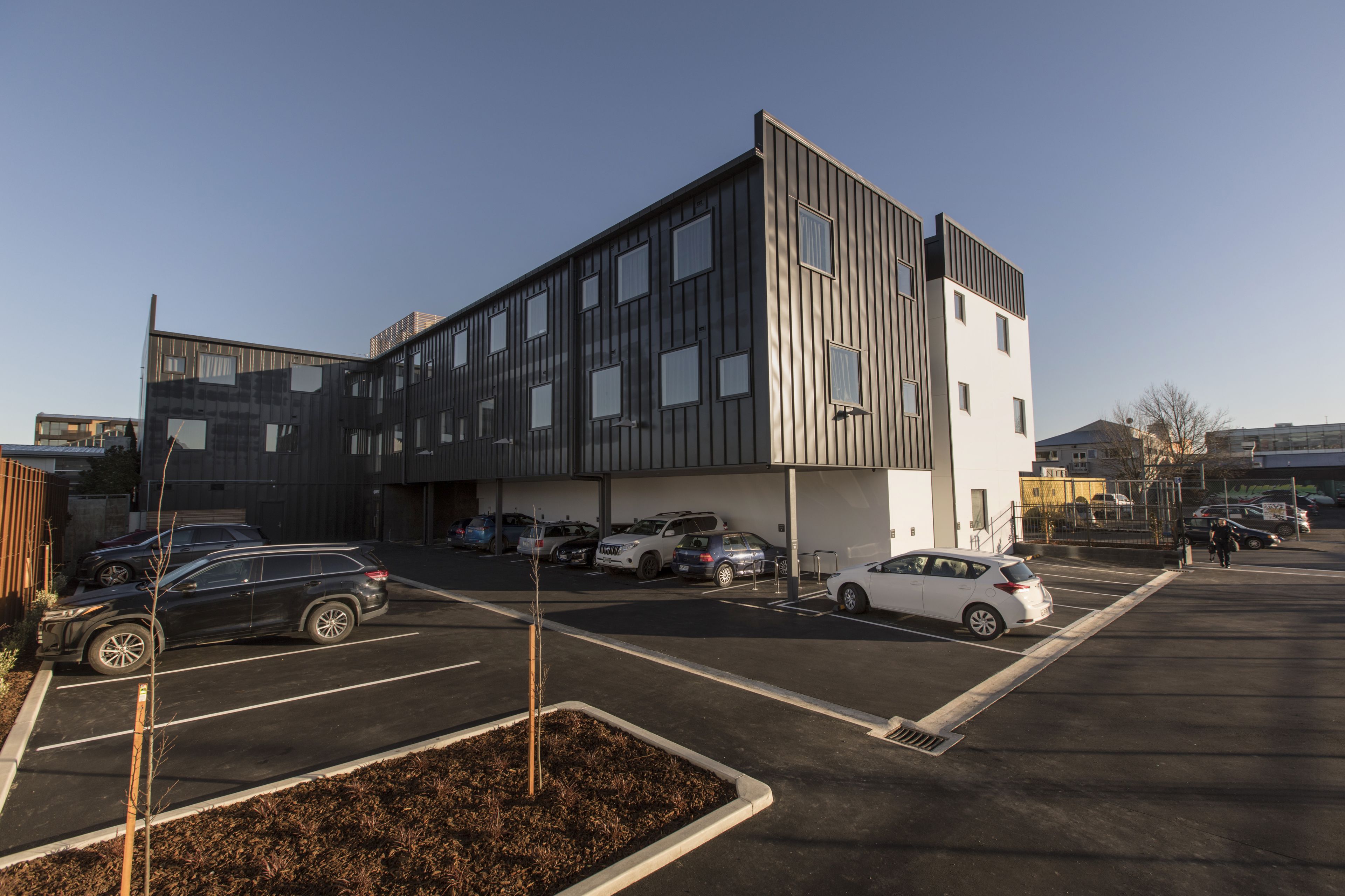 Een modern gebouw met een parkeerplaats ervoor.