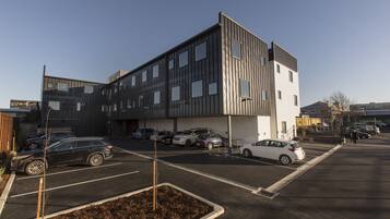 Een modern gebouw met een parkeerplaats ervoor.