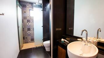 Un baño moderno con un lavamanos grande blanco, una encimera negra y un revestimiento de pared estampado.
