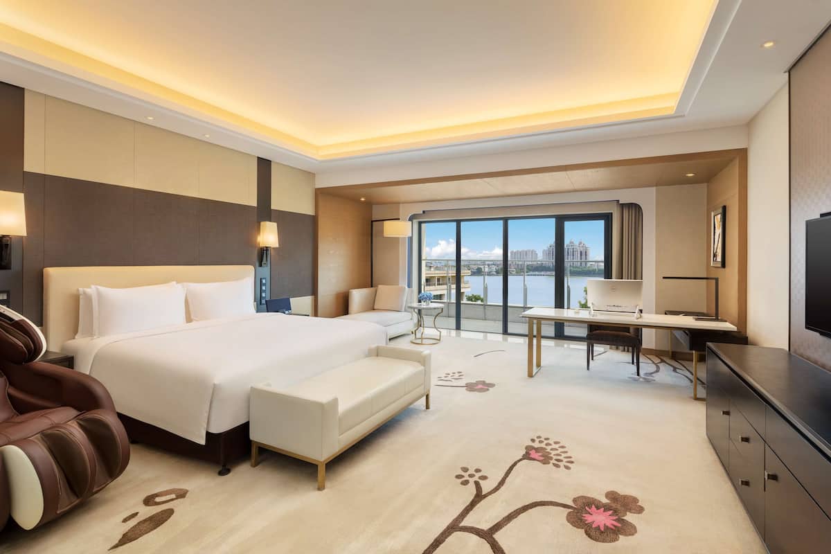 Une chambre d’hôtel moderne équipée d’un grand lit, d’un canapé, d’un bureau et d’une télévision.